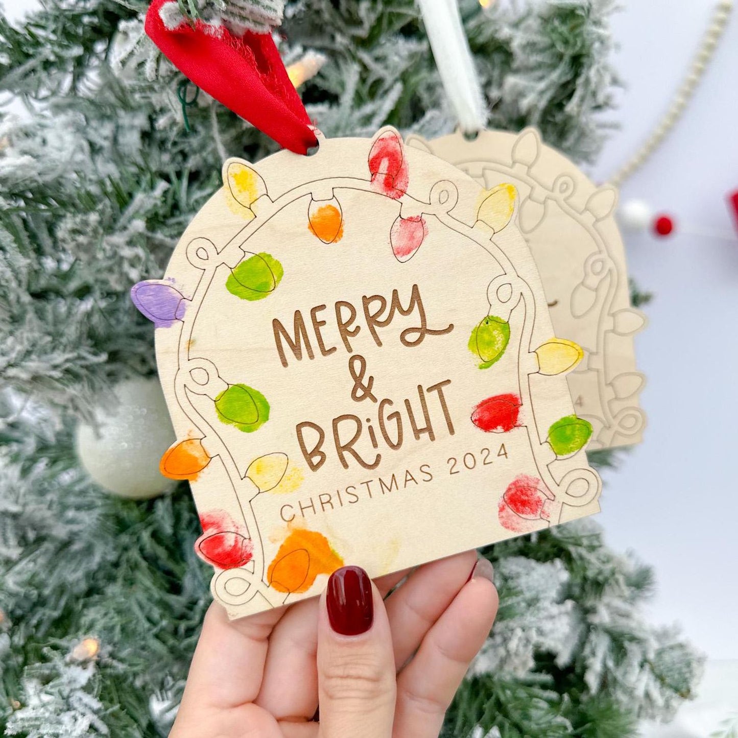 Close-up of a finished Personalized Fingerprint Keepsake showing brightly colored fingerprints filling the light shapes and the custom engraved year underneath.