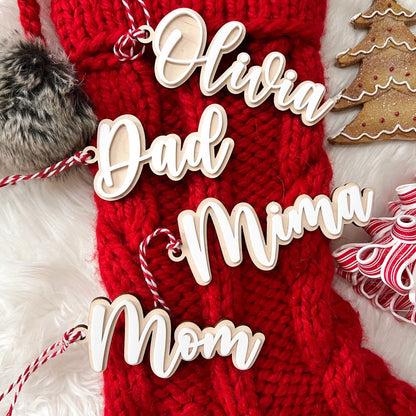 Group shot of several Personalized 3D Acrylic Stocking Tags (e.g., "Dad," "Mom," "Olivia") showcasing the layered depth and different names.