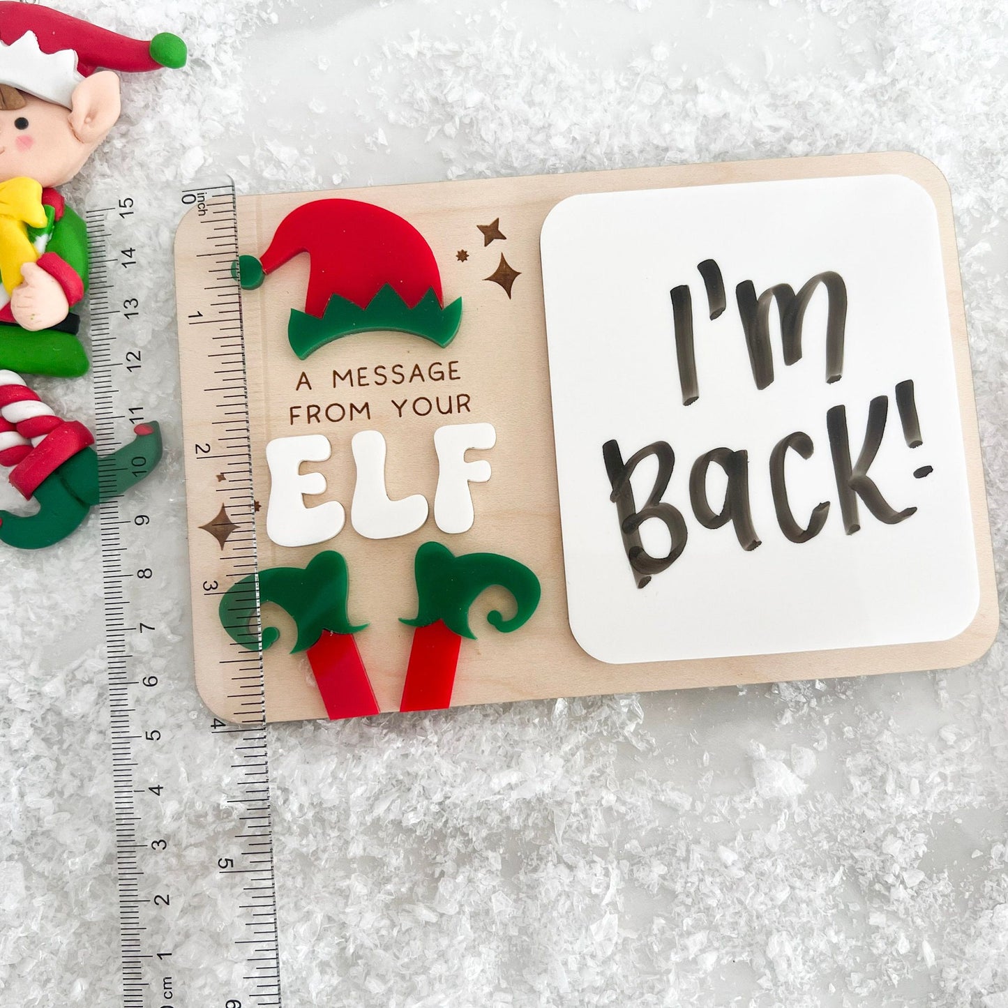 Hand writing a message on the Daily Elf Message Board, emphasizing the interactive and custom message capability.