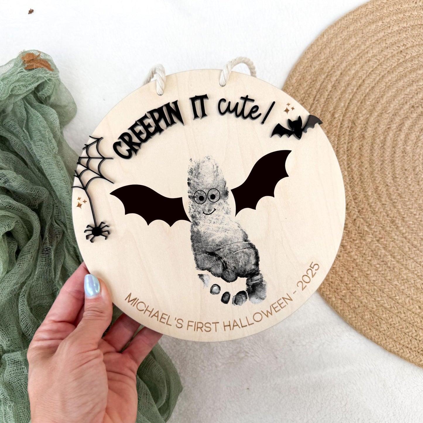 Close-up of Baby's First Halloween Handprint Sign with black acrylic "Creepin it cute!" overlay