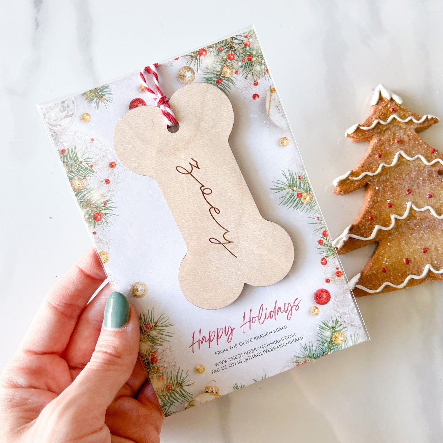 Wooden Dog Bone Stocking Tag with "Zoey" engraved, shown next to a Christmas sugar cookie