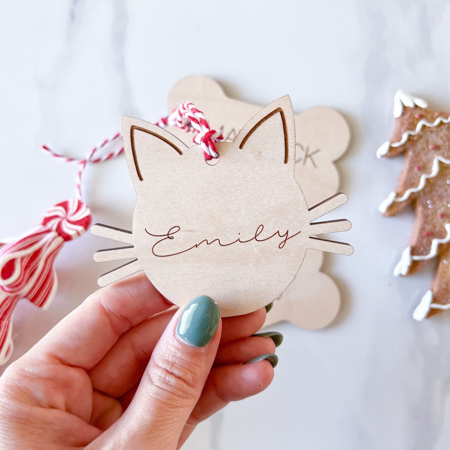 Detail of the Engraved Wooden Pet Keepsake showing the Cat Head shape and its twine tie, perfect for pet gift tags.