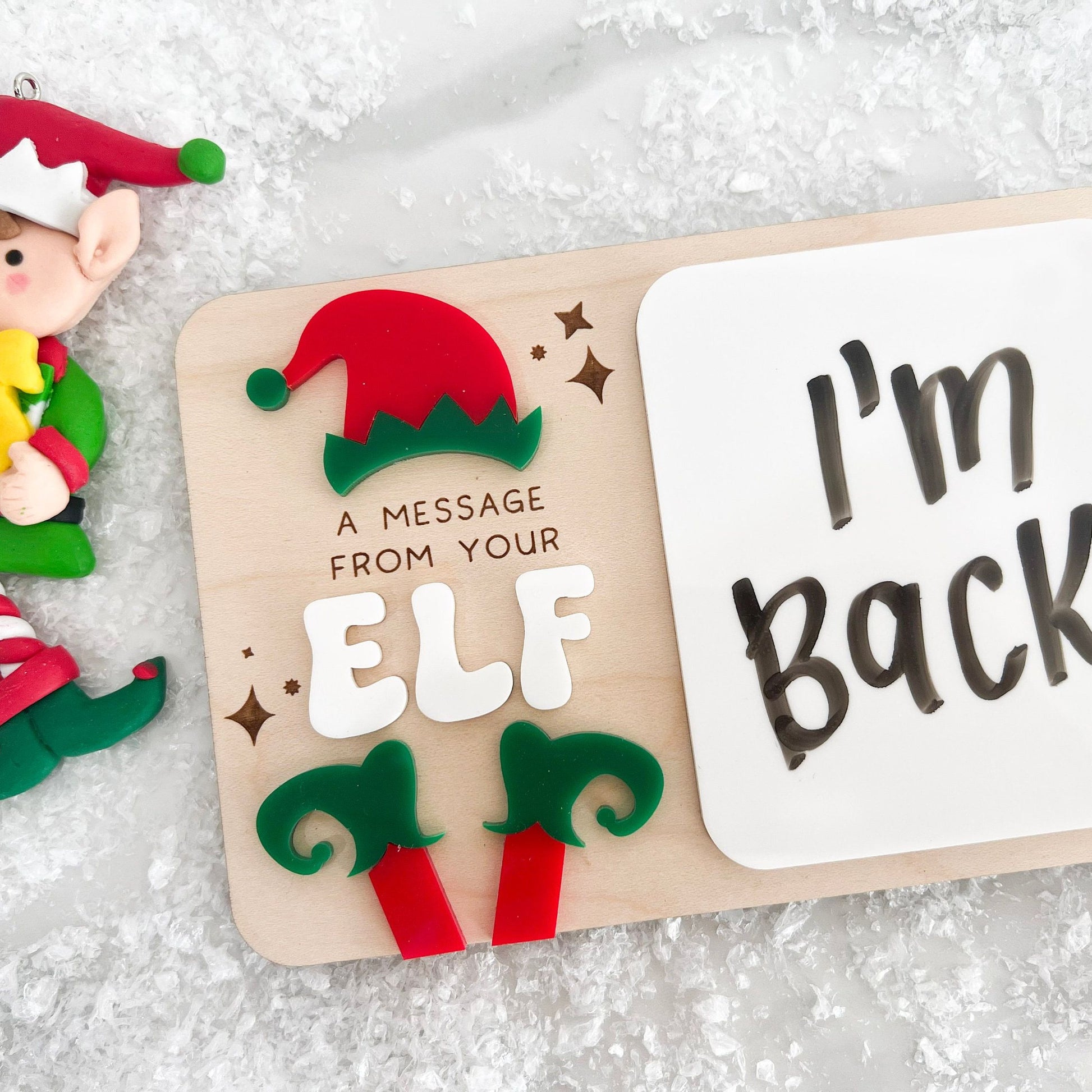 Dry Erase Elf Message Board Prop showing a written message, featuring the 3D acrylic red and green elf feet detail.