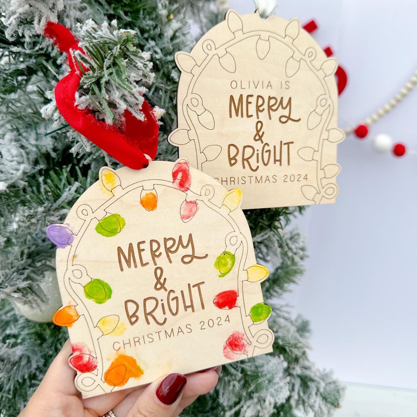 Close-up of a finished Personalized Fingerprint Keepsake showing brightly colored fingerprints filling the light shapes and the custom engraved name underneath.