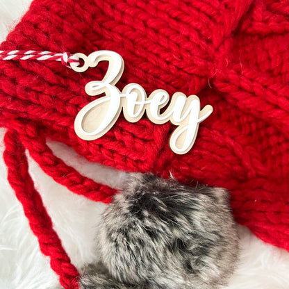 Close-up of 3D Layered Name Christmas Tag ("Zoey") with white acrylic on wood, hanging from a red knit stocking.