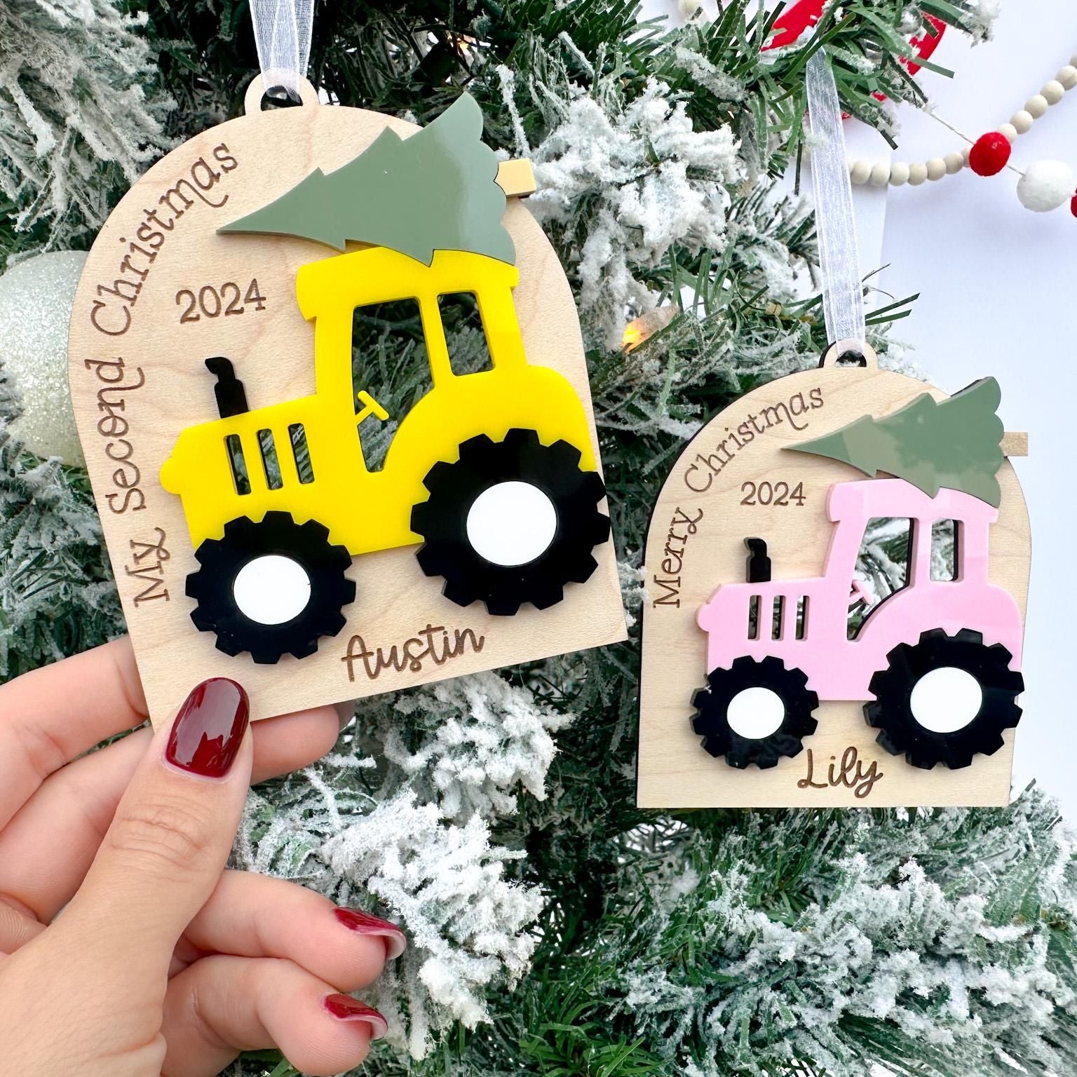 Close-up of the Custom Farm Ornament showing the child's name engraved beneath the tractor and the natural grain of the maple wood.