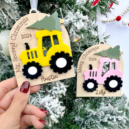 Close-up of the Custom Farm Ornament showing the child's name engraved beneath the tractor and the natural grain of the maple wood.
