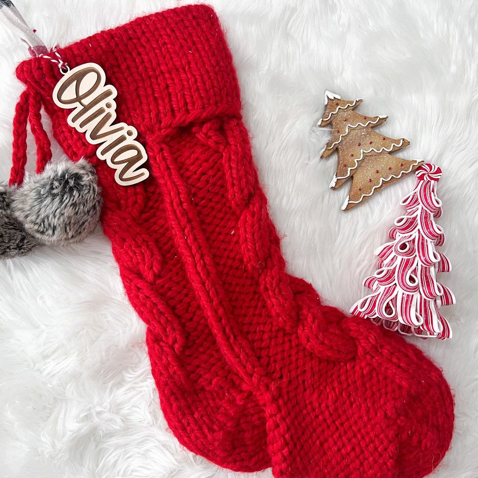 Personalized Christmas Stocking Tag featuring the name "Olivia" engraved in a playful block font on a red knit stocking.