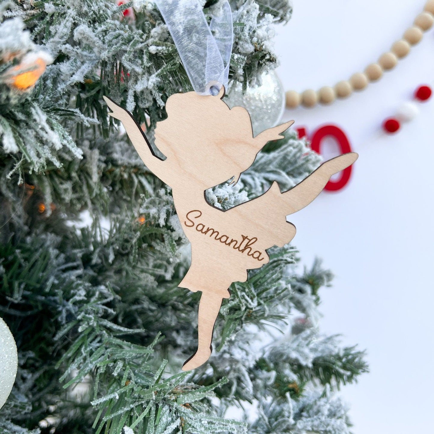 Engraved Ballerina Silhouette ornament hung on a Christmas tree, emphasizing the 4-inch size and its use as a dance recital gift.