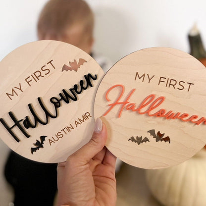 Two Halloween Milestone Discs side-by-side (black and orange acrylic options) showing the variations in wood grain.