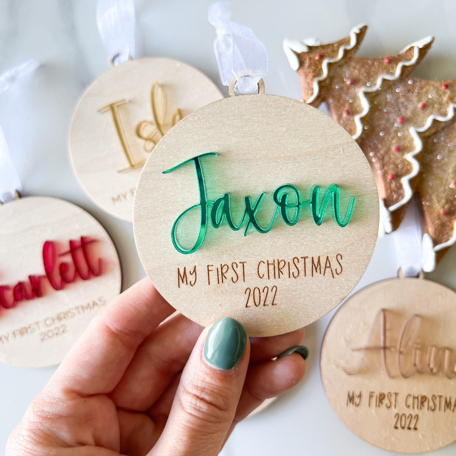 Personalized Baby's First Christmas Ornament with "Jaxon" in 3D green acrylic, featuring engraved text "MY FIRST CHRISTMAS 2022" on the wood.