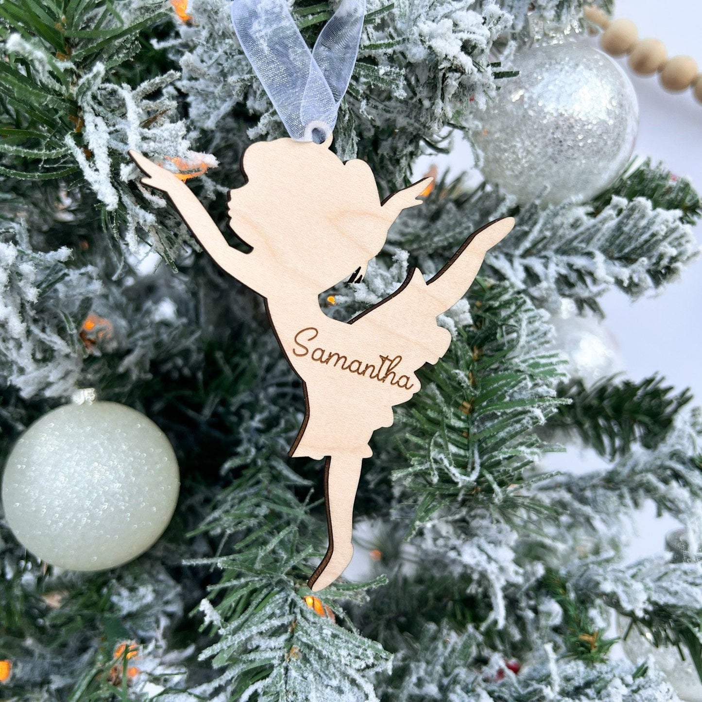 Detail shot of the personalized Dancer Ornament showing the crisp engraved script name and the laser-cut edges of the wood.