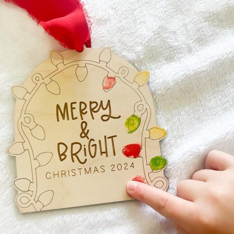 Close-up of a finished Personalized Fingerprint Keepsake showing brightly colored fingerprints filling the light shapes and the custom engraved year underneath.