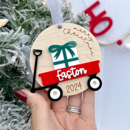 Personalized Wagon Christmas Ornament featuring the "Merry Christmas" saying and a layered name in white acrylic, showing a red wagon color choice.