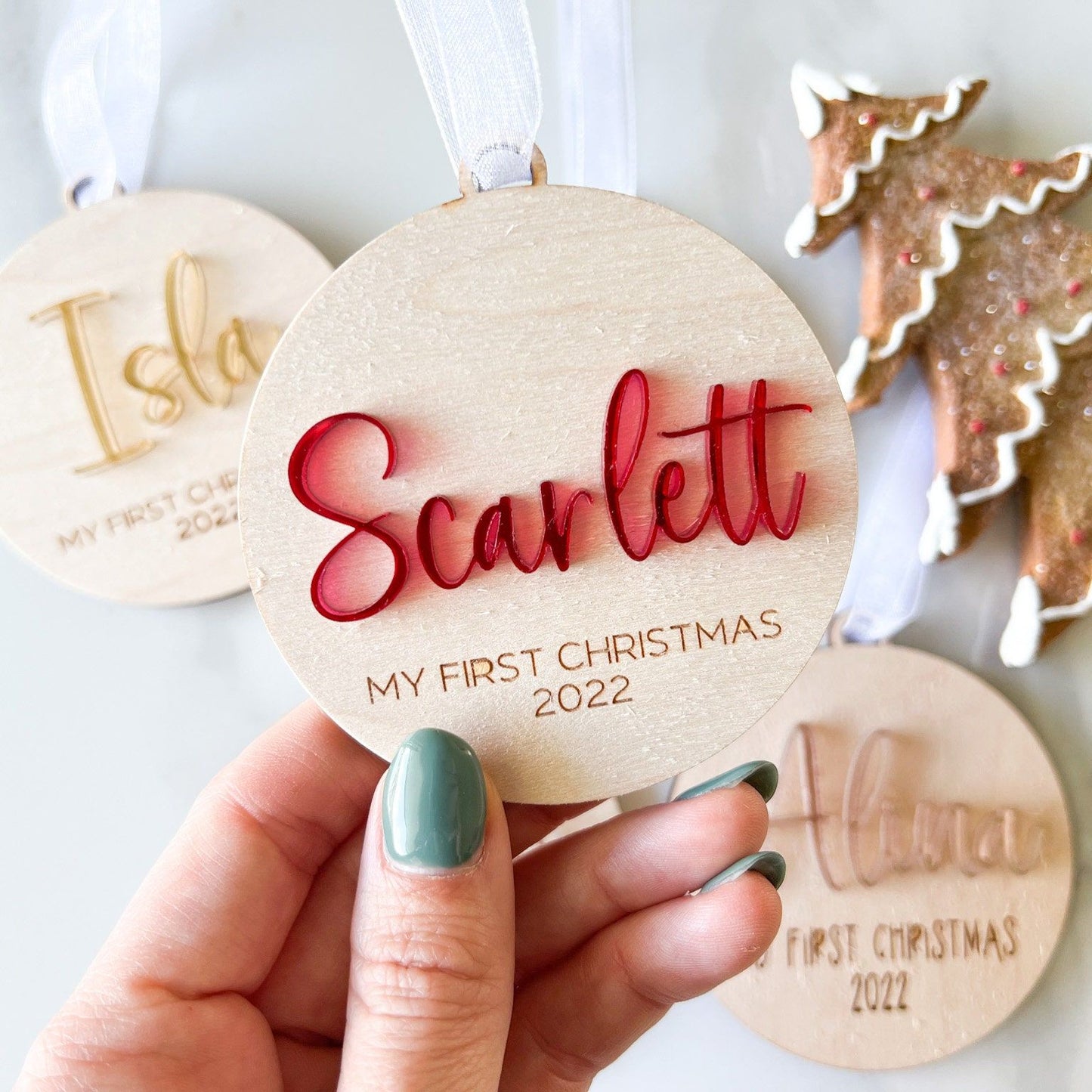 Close-up of the Custom Keepsake Ornament showing the layered 3D acrylic name ("Scarlett" in red) and the detailed laser-engraved year.