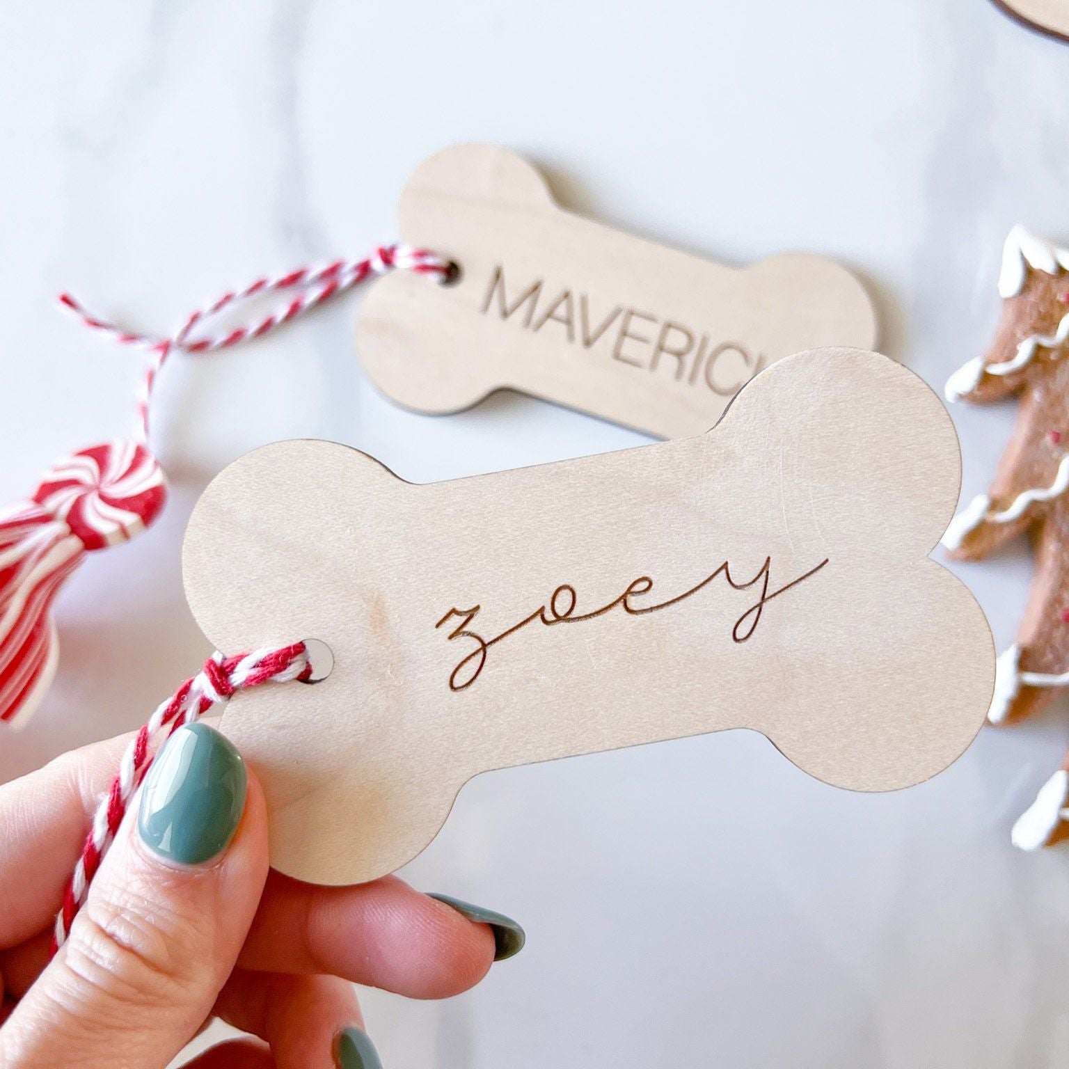 Custom Pet Name Christmas Ornament (Bone shape) being held up to show close up details.