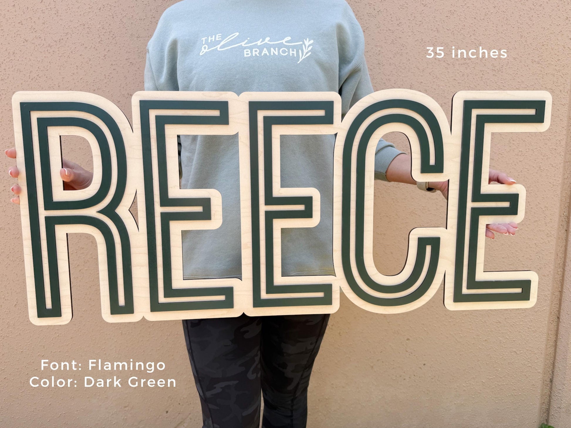 Baby nursery sign with green 3D name.  A wooden sign spelling "REECE" in a Flamingo font with dark green accents. The sign is 35 inches wide. The text "Font: Flamingo Color: Dark Green" is at the bottom.