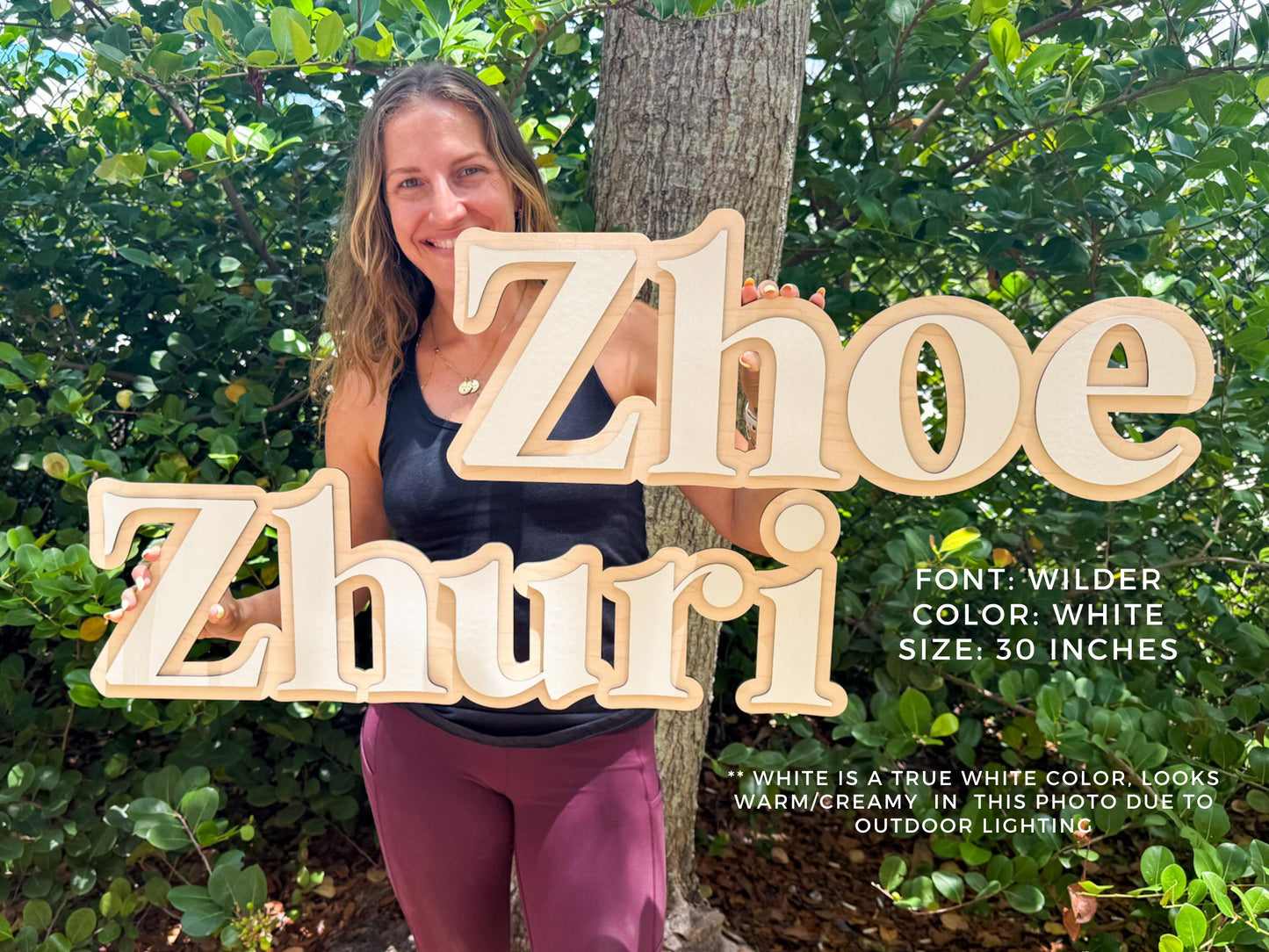 Baby nursery personalized name sign. Wooden name signs, "Zhoe" and "Zhuri", in a Wilder font with a white color. Each sign is 30 inches in size. The signs have a layered design with a natural wood and white color scheme. The text "FONT: WILDER COLOR: WHITE SIZE: 30 INCHES" is also visible.