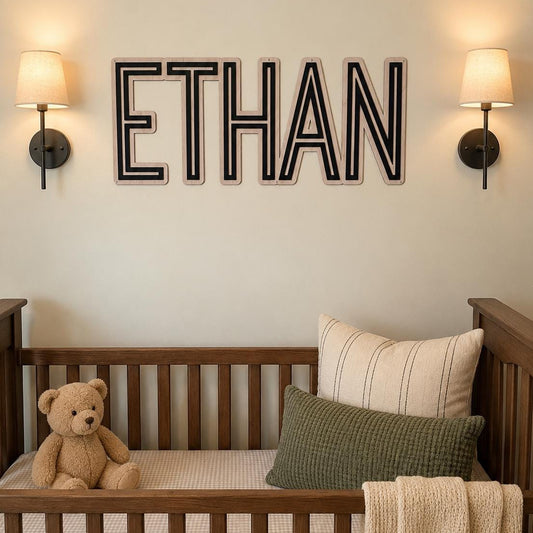 Modern personalized wooden nursery name sign displayed above a crib in a neutral nursery with warm wood furniture, custom baby name wall decor and contemporary layered lettering.