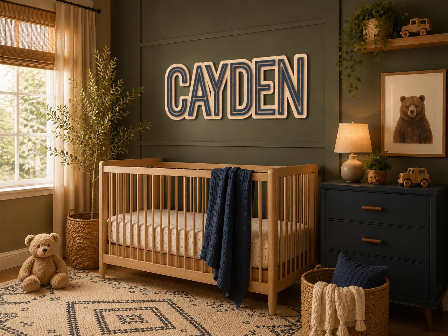 Modern personalized wooden name sign displayed above a crib in a luxury nursery with dark green accent wall, warm wood furniture, and custom layered lettering.
