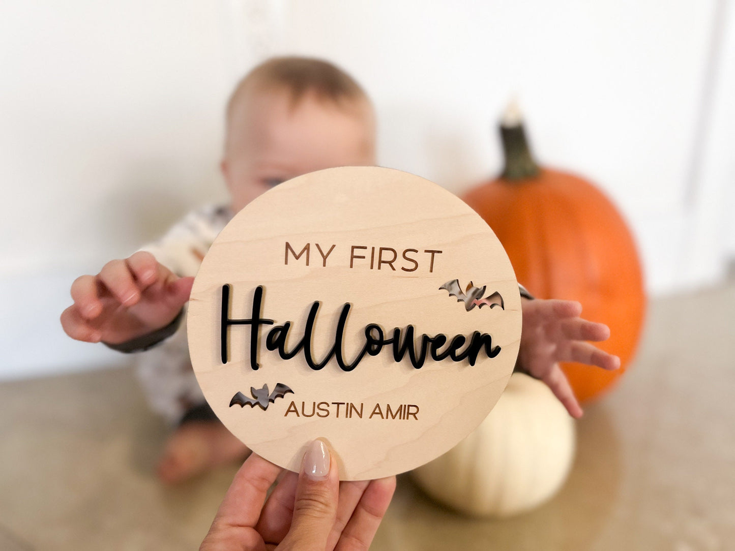 Lifestyle shot of the 6-inch wooden round near seasonal decorations, perfect for spooky season nursery decor.